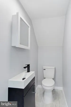 a bathroom with a toilet a sink and mirror
