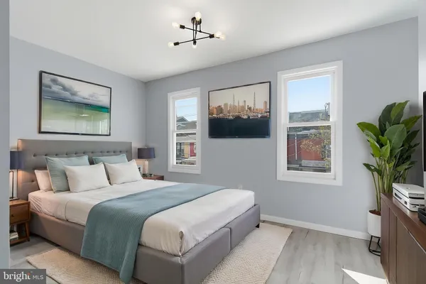 a bedroom with a large bed painting on the wall and a window