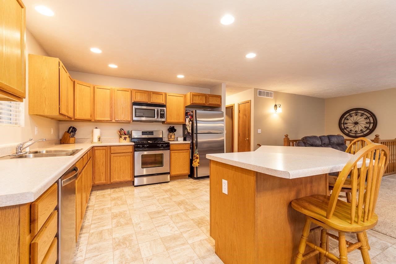 643 Knollwood Road Davis, IL 61019 - Photo 6 of 26 a kitchen with stainless steel appliances granite countertop a sink a stove a refrigerator cabinets and a dining table