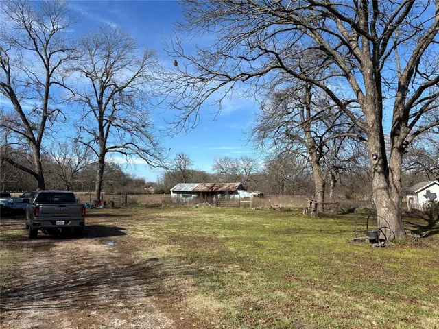 a view of a yard with cars on road