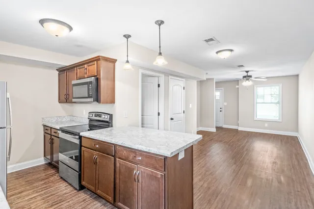 a kitchen with stainless steel appliances granite countertop a sink and a refrigerator