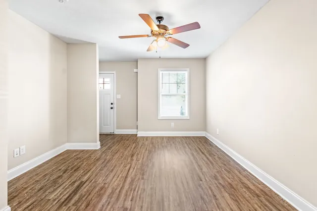 a large kitchen with a lot of counter space and wooden floor