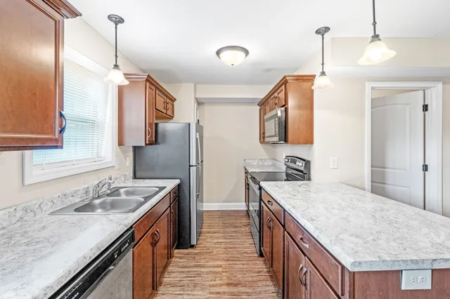 a kitchen that has a sink a stove and a wooden floor