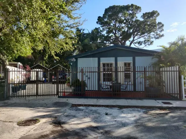 a view of a house with a small yard and wooden fence
