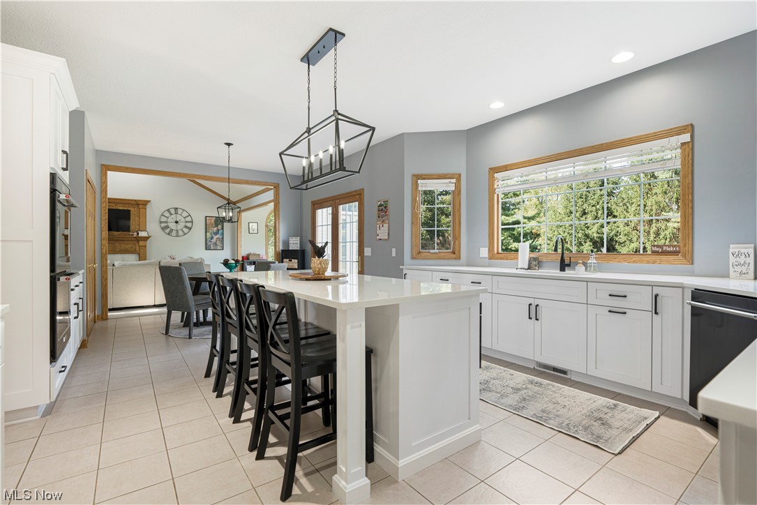 939 Pontius Road Mogadore, OH 44260 - Photo 5 of 35 Kitchen with light tile floors, white cabinetry, an inviting chandelier, pendant lighting, and stainless steel appliances