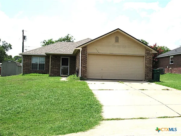a front view of a house with a garden and garage