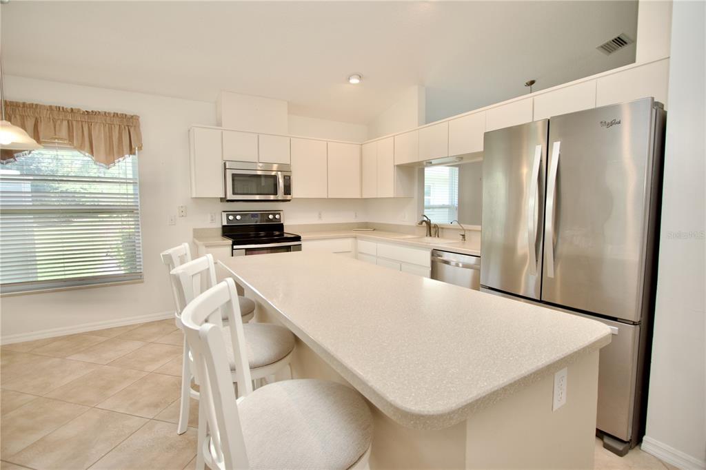 7842 Tenby Court New Port Richey, FL 34655 - Photo 10 of 27 a kitchen with kitchen island a refrigerator stove and microwave
