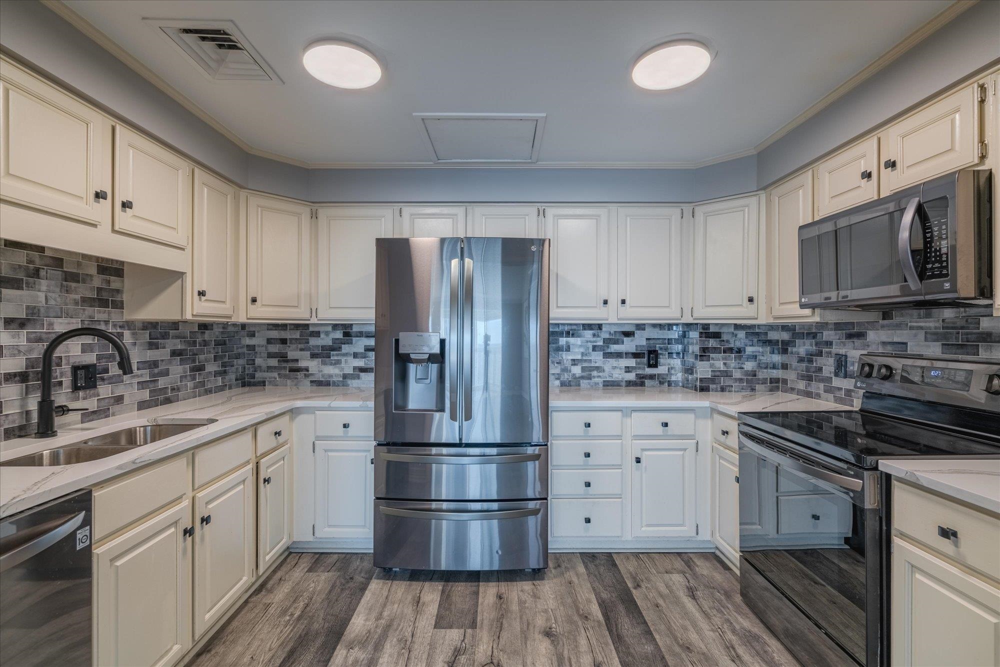 655 Riverside Drive, Unit 904B Memphis, TN 38103 - Photo 18 of 39 a kitchen with white cabinets white stainless steel appliances and sink
