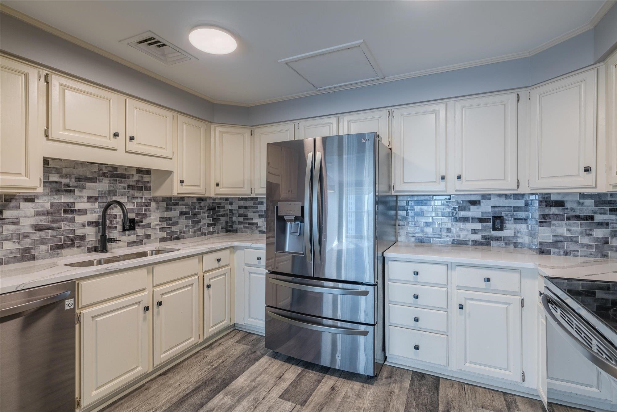 655 Riverside Drive, Unit 904B Memphis, TN 38103 - Photo 19 of 39 a kitchen with white cabinets white stainless steel appliances and sink