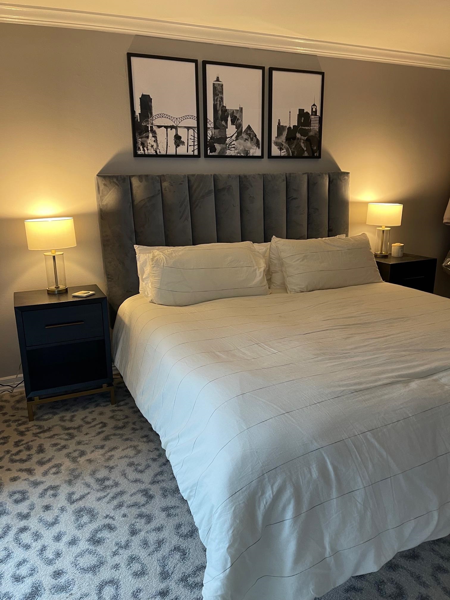 655 Riverside Drive, Unit 904B Memphis, TN 38103 - Photo 22 of 39 a bed sitting in a bedroom next to a lamp