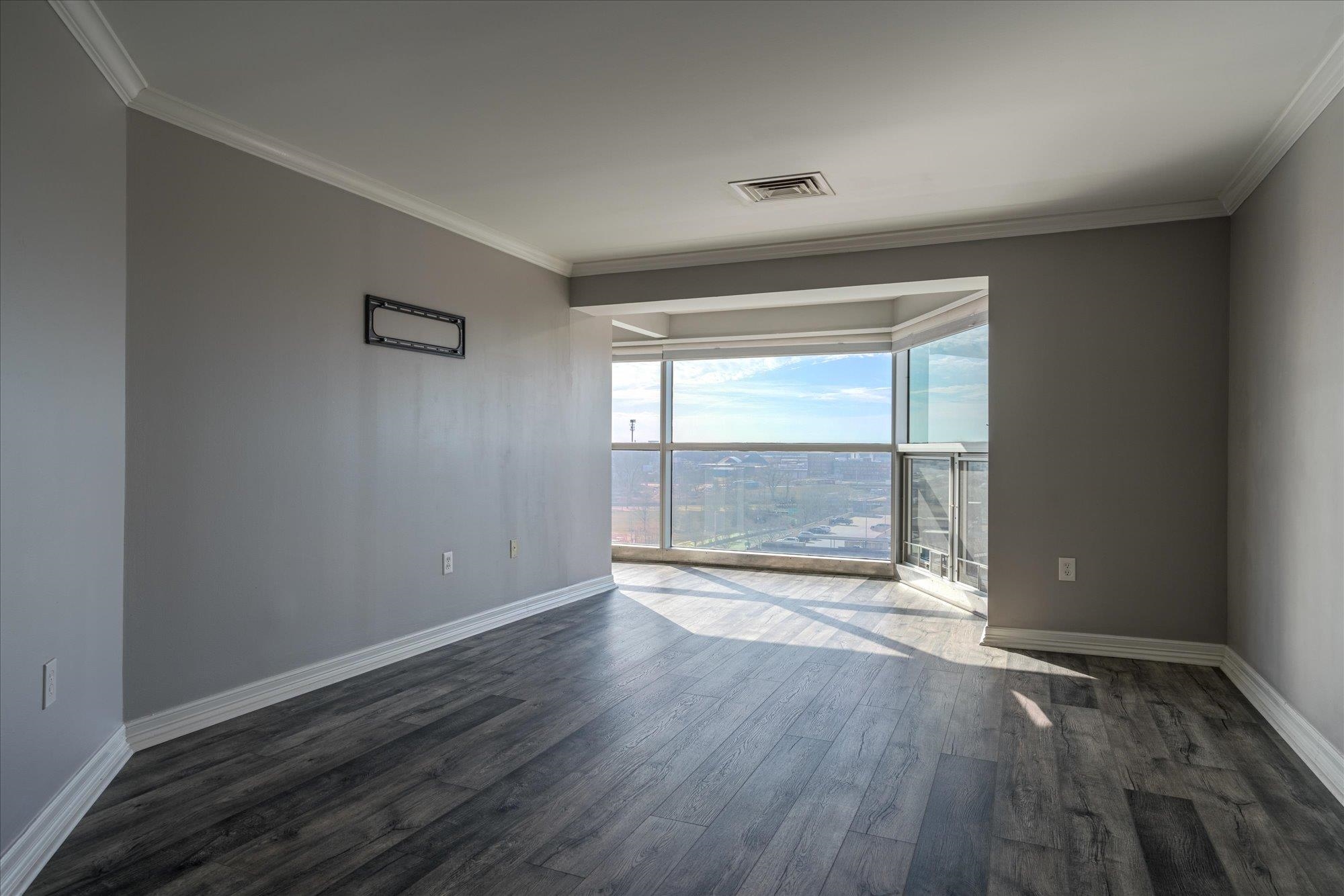 655 Riverside Drive, Unit 904B Memphis, TN 38103 - Photo 24 of 39 an empty room with wooden floor and windows