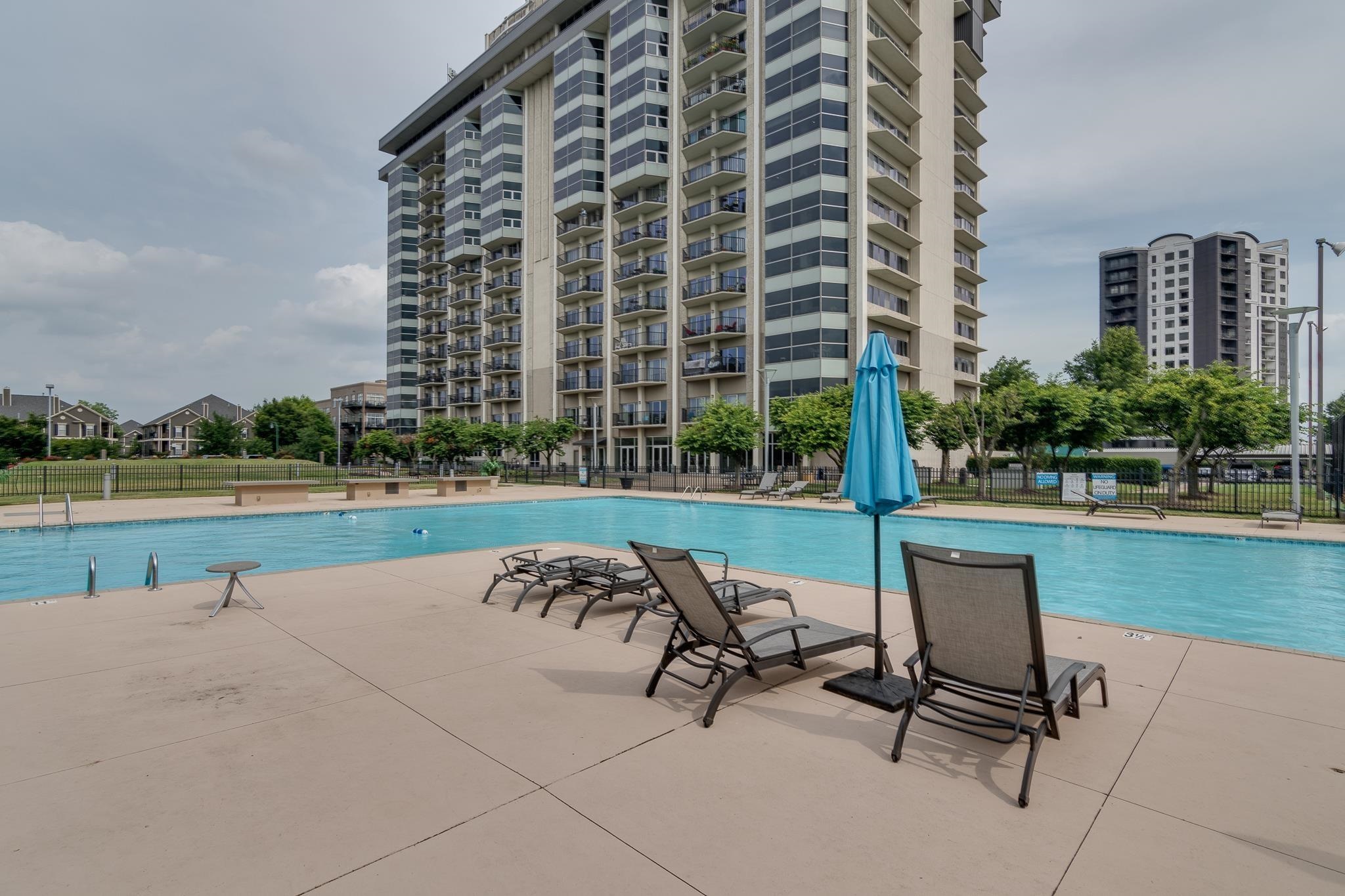 655 Riverside Drive, Unit 904B Memphis, TN 38103 - Photo 28 of 39 a view of a swimming pool with chairs and a yard in back