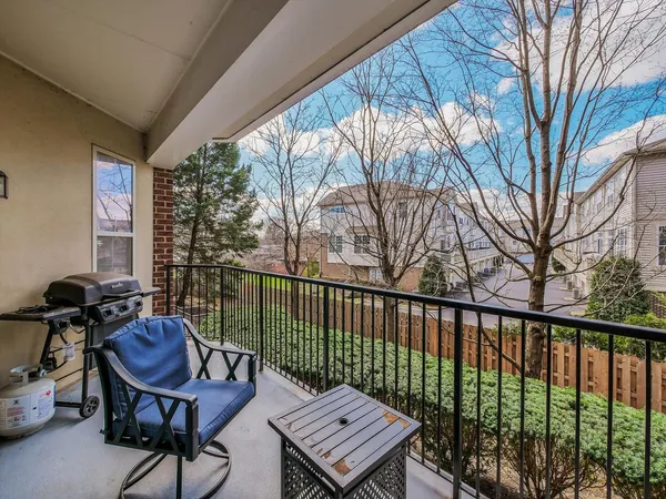 a view of a balcony with furniture and a large window