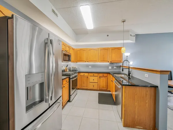 a kitchen with stainless steel appliances granite countertop a sink and a refrigerator
