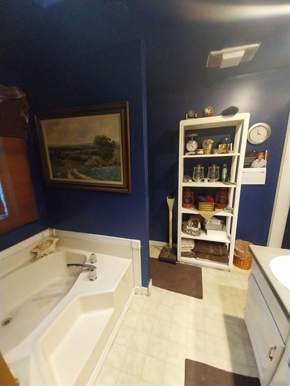 4415 Smallwood Road Reno, TX 75462 - Photo 33 of 39 a spacious bathroom with a bathtub and a book shelf