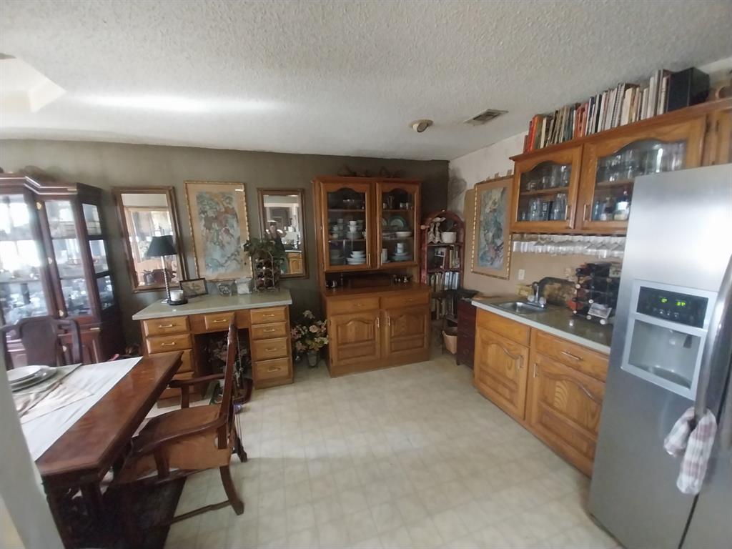 4415 Smallwood Road Reno, TX 75462 - Photo 8 of 39 a kitchen with stainless steel appliances kitchen island granite countertop a stove a sink a dining table and chairs