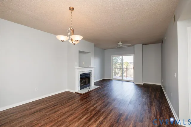 a view of a room with wooden floor fireplace and window