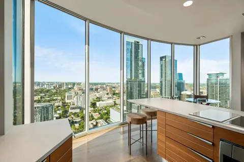 a living room with furniture and floor to ceiling windows