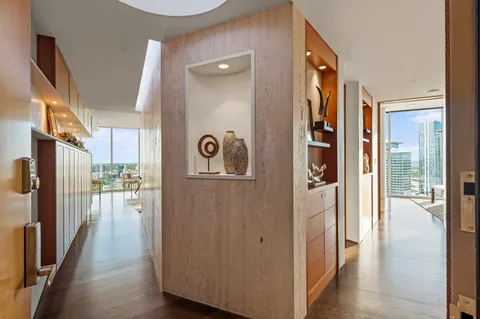 a view of hallway with wooden floor and cabinets