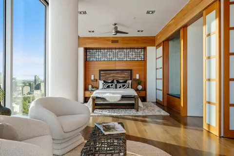 a bedroom with a bed lamp and a large window