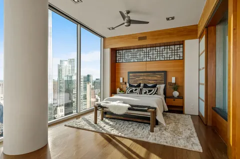 a spacious bedroom with a large window and a bed