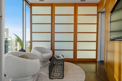 a bedroom with a bed and large windows