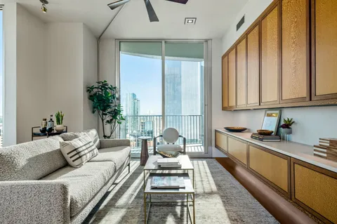 a living room with furniture and floor to ceiling windows