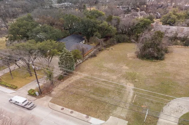 a view of a dry yard covered with snow in the background