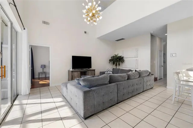 a living room with furniture and a dining table with kitchen view