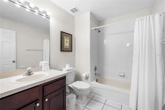 a bedroom with a bed and a flat tv screen on the dresser