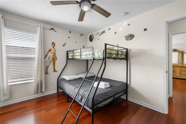 a bedroom with a bed and wooden floor
