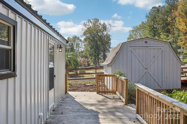 a view of backyard with small cabin and wooden fencing