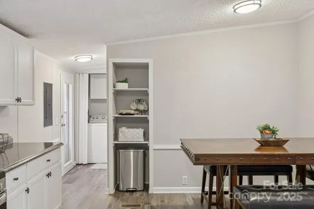a kitchen with stainless steel appliances refrigerator dining table and chairs