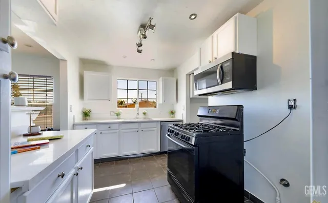 a kitchen with stainless steel appliances a sink dishwasher stove microwave and refrigerator