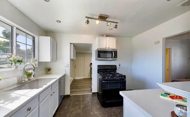 a kitchen with stainless steel appliances a sink stove and refrigerator