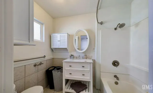 a bathroom with a tub sink mirror vanity and toilet