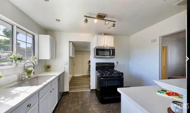 a kitchen with stainless steel appliances a sink stove and refrigerator