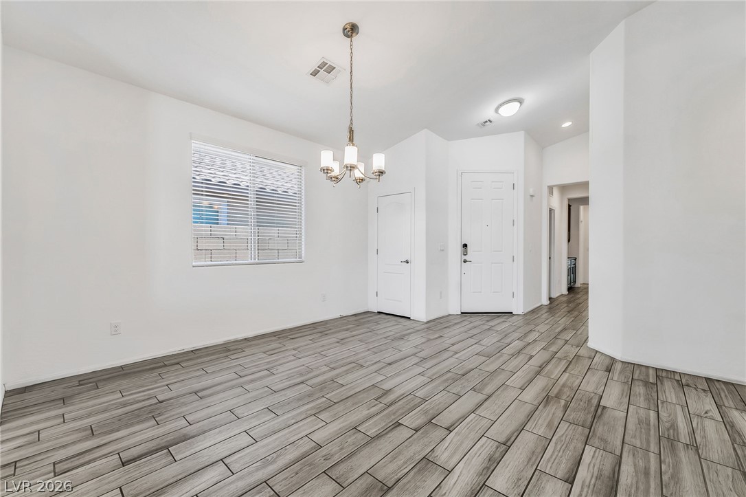 6245 Andover Wood Road Las Vegas, NV 89113 - Photo 6 of 37 A well-lit interior space with sleek wood-look tile flooring.