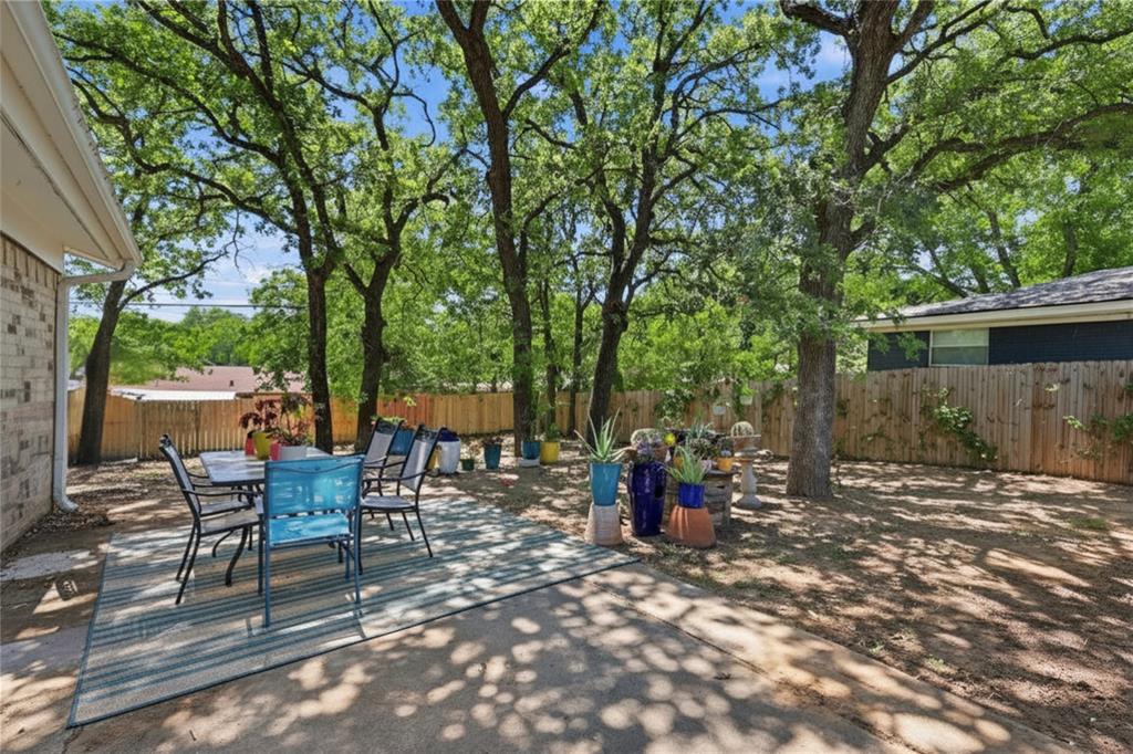 16 Coffee Tavern Road Bedford, TX 76022 - Photo 19 of 24 Spacious backyard featuring a concrete patio, mature trees, and privacy fencing