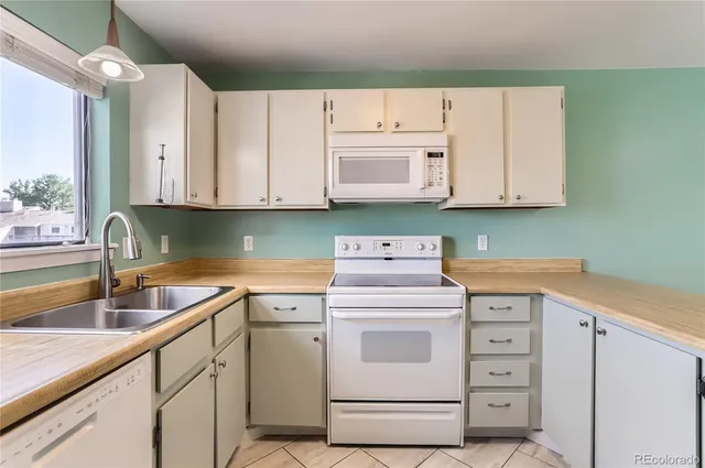 a kitchen with cabinets appliances a sink and a counter top