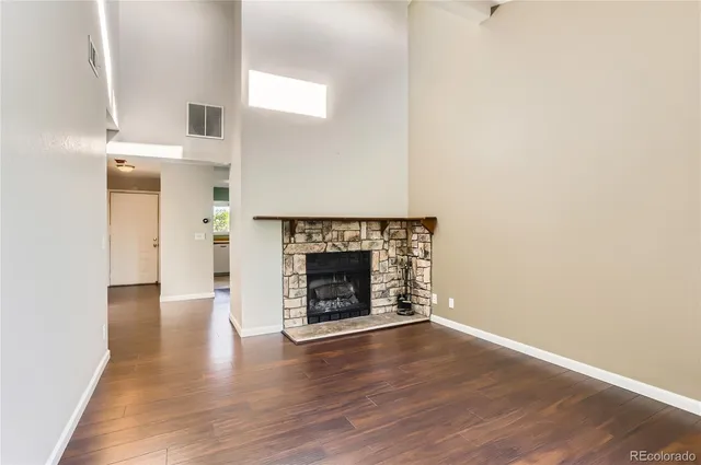 a view of a livingroom with wooden floor and a fireplace