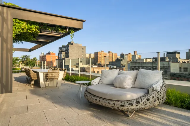 a roof deck with couch and chairs
