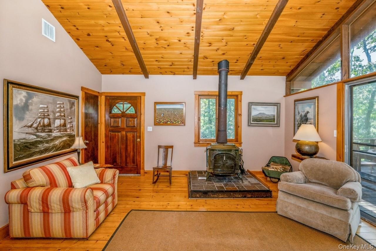 292 Little Fresh Pond Road Southampton, NY 11968 - Photo 15 of 46 Living room featuring a wood stove, high ceiling with beams, light hardwood / wood-style flooring, and wooden ceiling