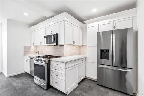 a kitchen with stainless steel appliances white cabinets and a granite counter tops