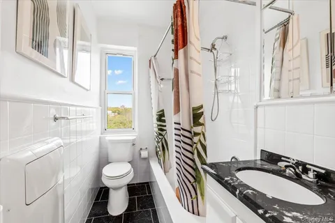 a bathroom with a granite countertop sink toilet a mirror and shower