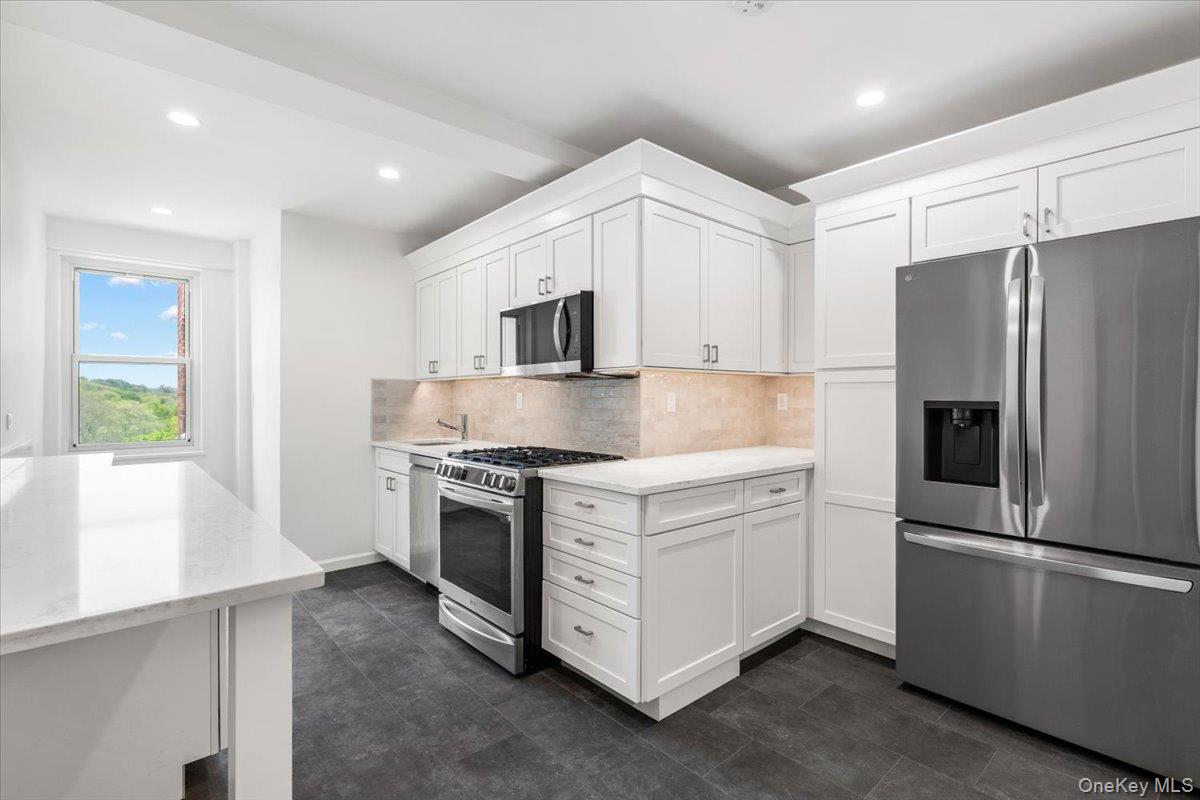 900 Palmer Road, Unit 10D Bronxville, NY 10708 - Photo 9 of 18 a kitchen with stainless steel appliances a refrigerator sink and microwave