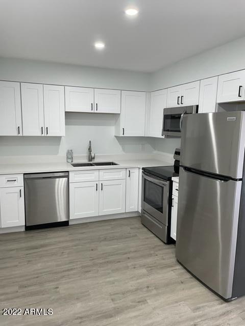 830 East Turney Avenue, Unit 9 Phoenix, AZ 85014 - Photo 7 of 28 a kitchen with white cabinets and white appliances