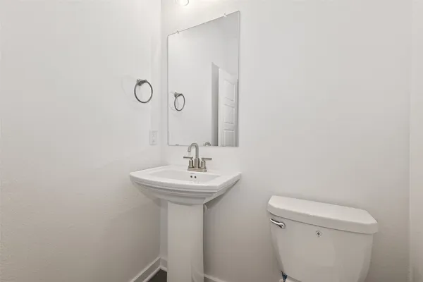 a bathroom with a sink a toilet and mirror