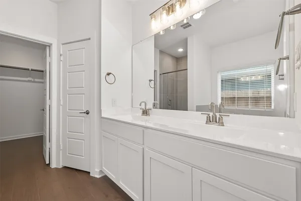 a bathroom with a double vanity sink a mirror and a shower