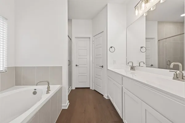a bathroom with a tub a sink and mirror